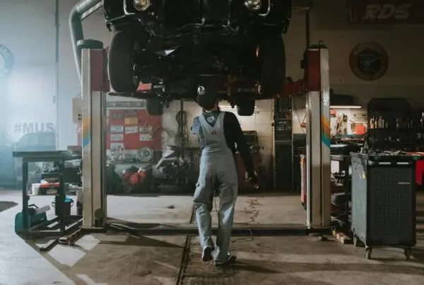 Uitzendkracht werkt aan een auto in garage